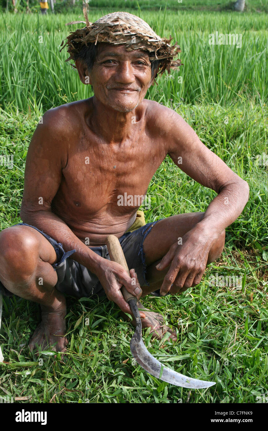 Ein Bali Aga Tribesman sitzen eine Sense hält Stockfoto