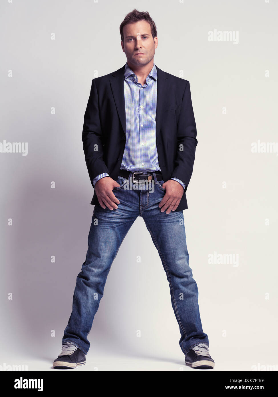 Modisch gekleideter Mann in den Dreißigern trägt Jeans und eine modische Jacke Stockfoto