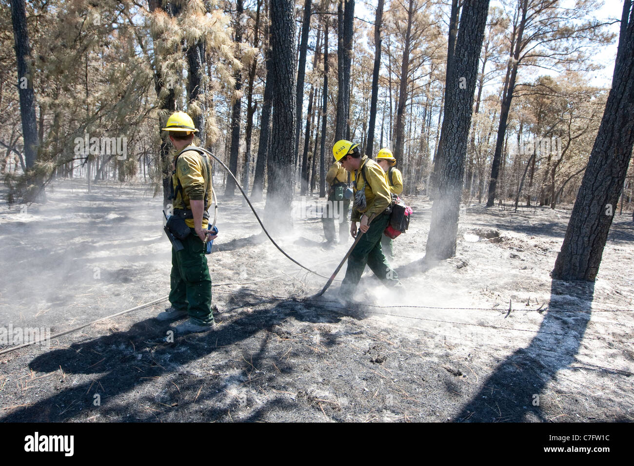 Feuerwehr überwachen und löschte kleine Brände in Bastrop, Texas eine Woche nach massiven Waldbränden fegte durch die Gegend Stockfoto