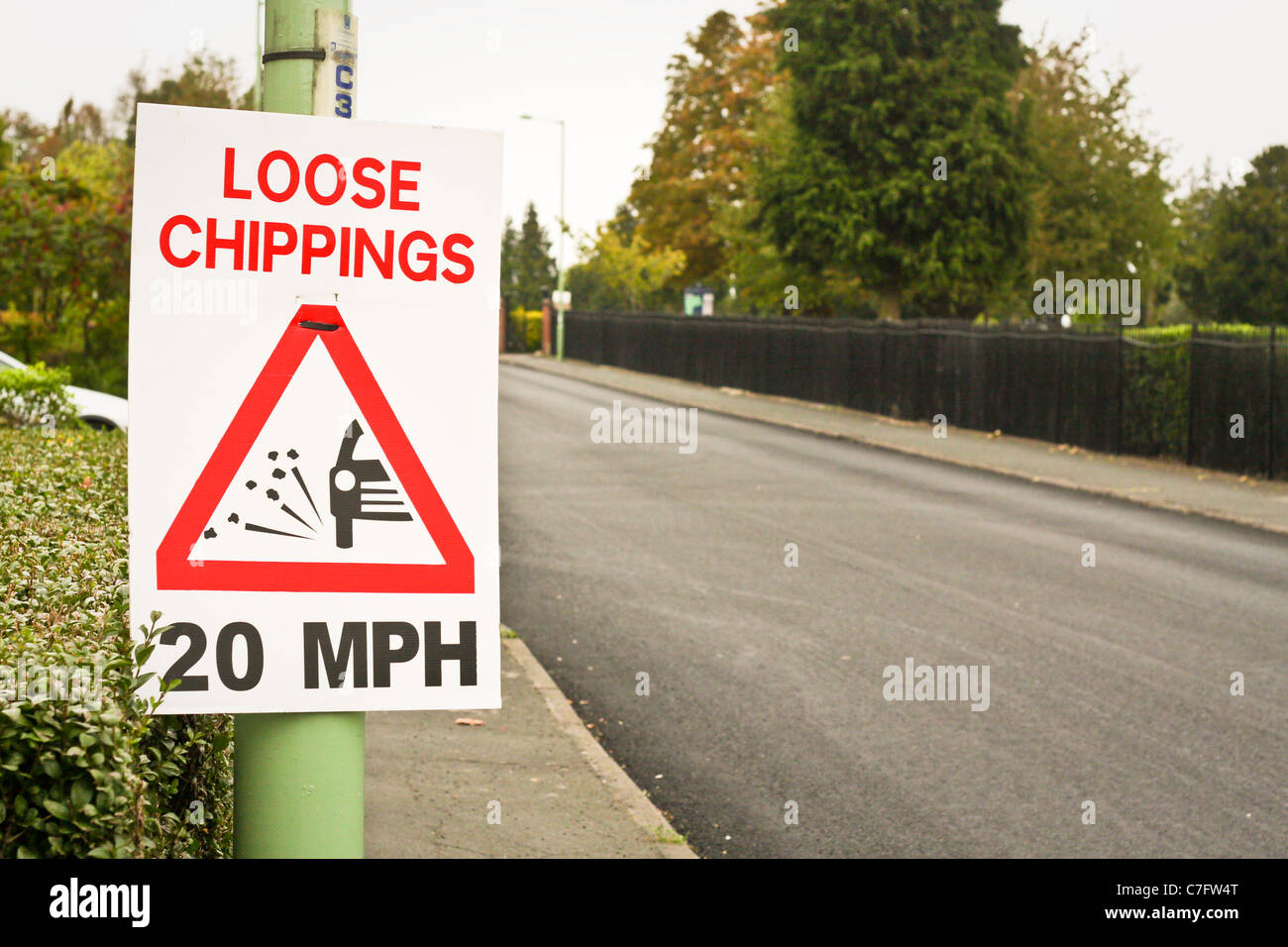 Losen Splitt Warnzeichen durch eine neu neu asphaltierte Straße in England Stockfoto