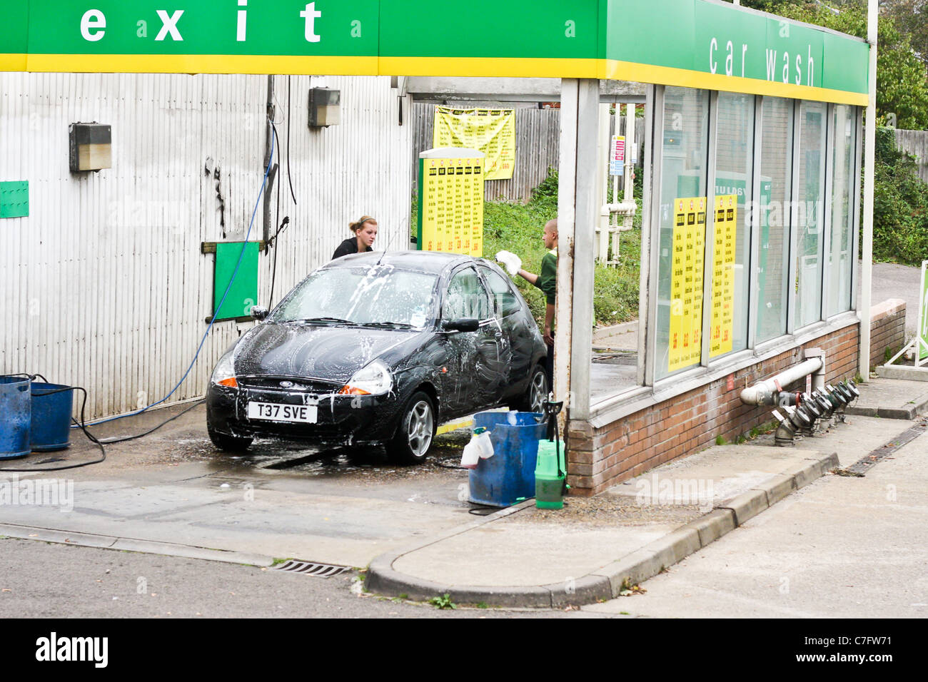 Menschen waschen einen Ford Ka in einer Hand-Autowaschanlage in Bury St Edmunds, Suffolk Stockfoto