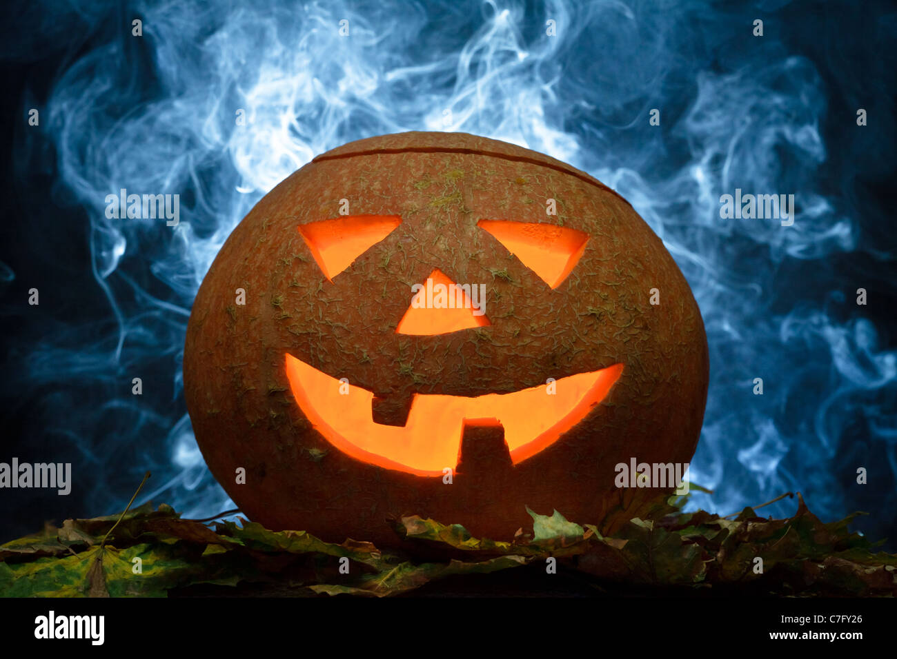 Halloween-Kürbis auf Blätter mit blauer Rauch Stockfoto