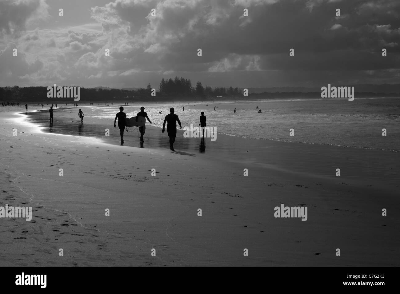 Surfer zu Fuß entlang der Main Beach, Byron Bay, Australien Stockfoto