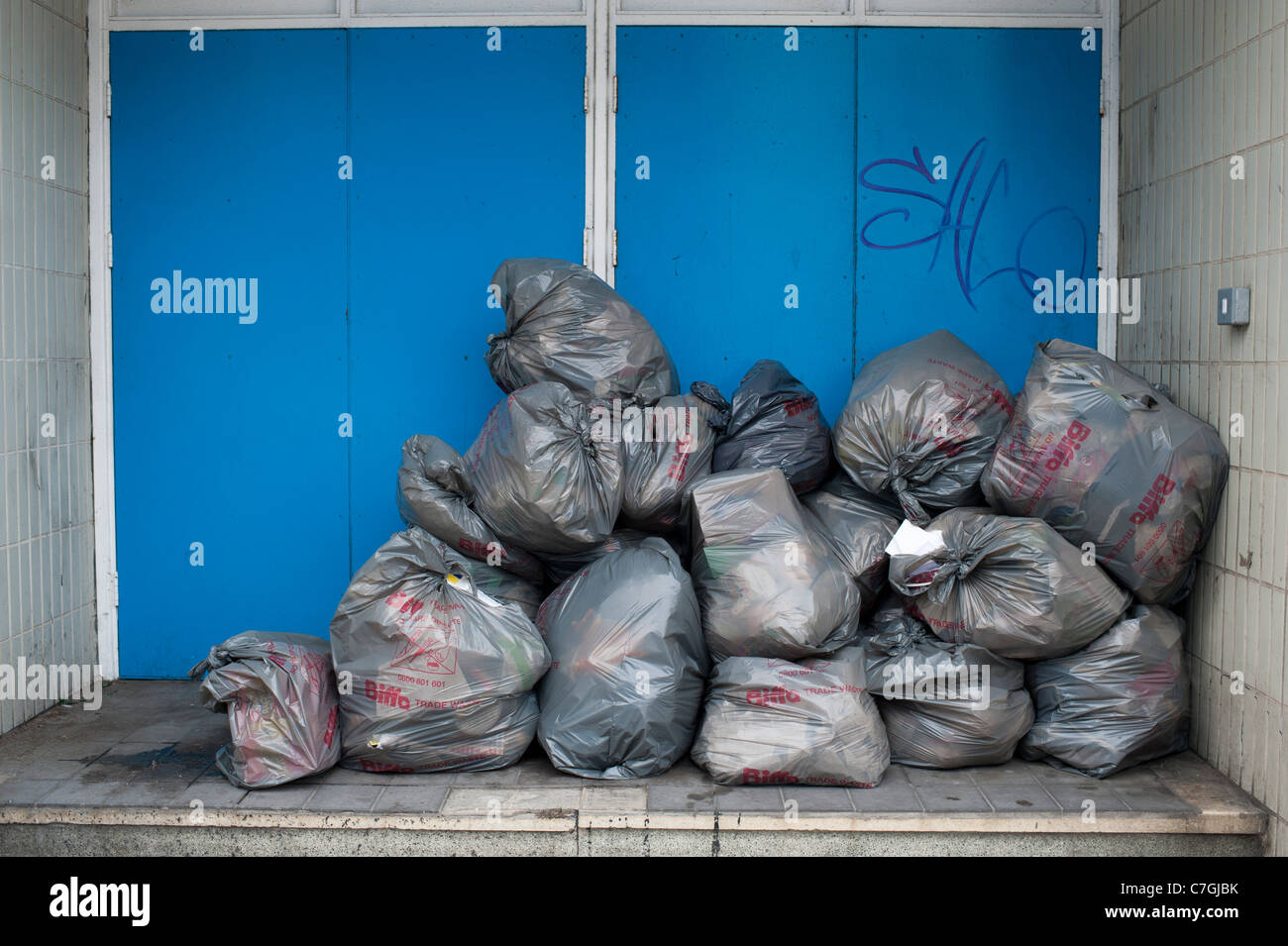 Graue Kunststoff Biffa Handel Müllsäcke außerhalb eines Ladens, UK Stockfoto