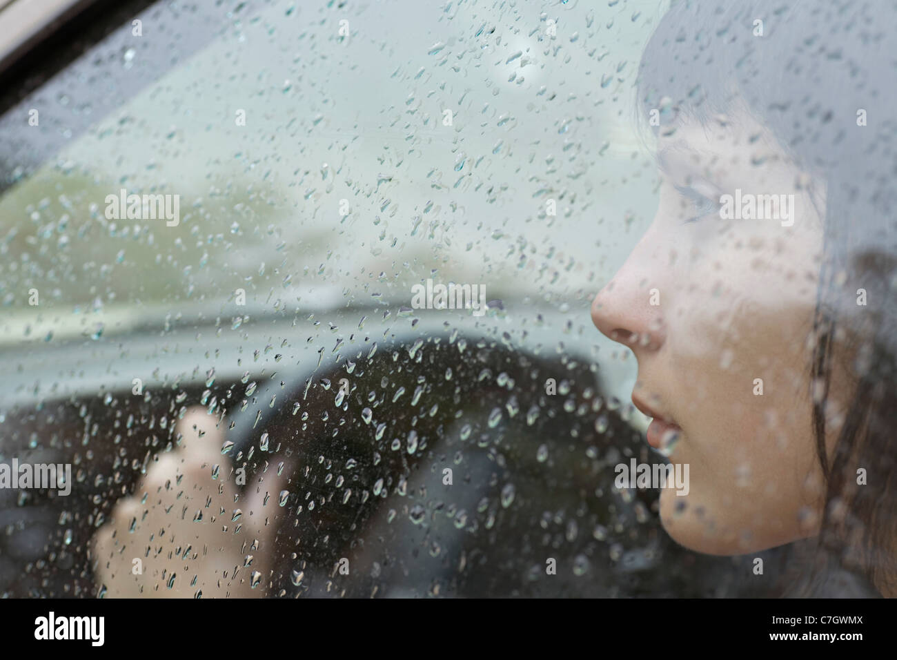 Eine Frau-Fahrer im Auto suchen Fenster, Regentropfen am Fenster sitzen Stockfoto