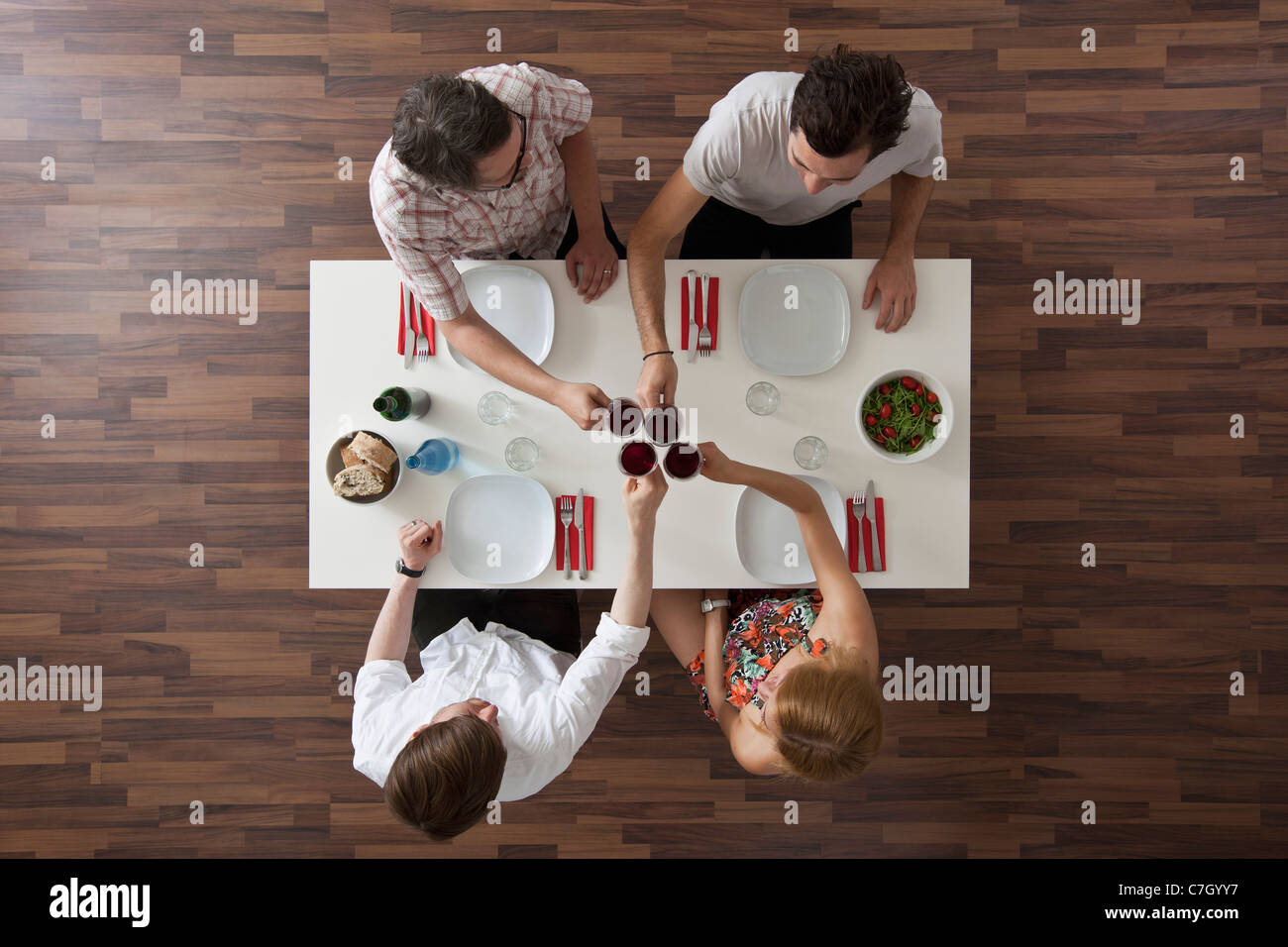 Vier Freunde, die bei einer Dinnerparty, Draufsicht Toasten Stockfoto