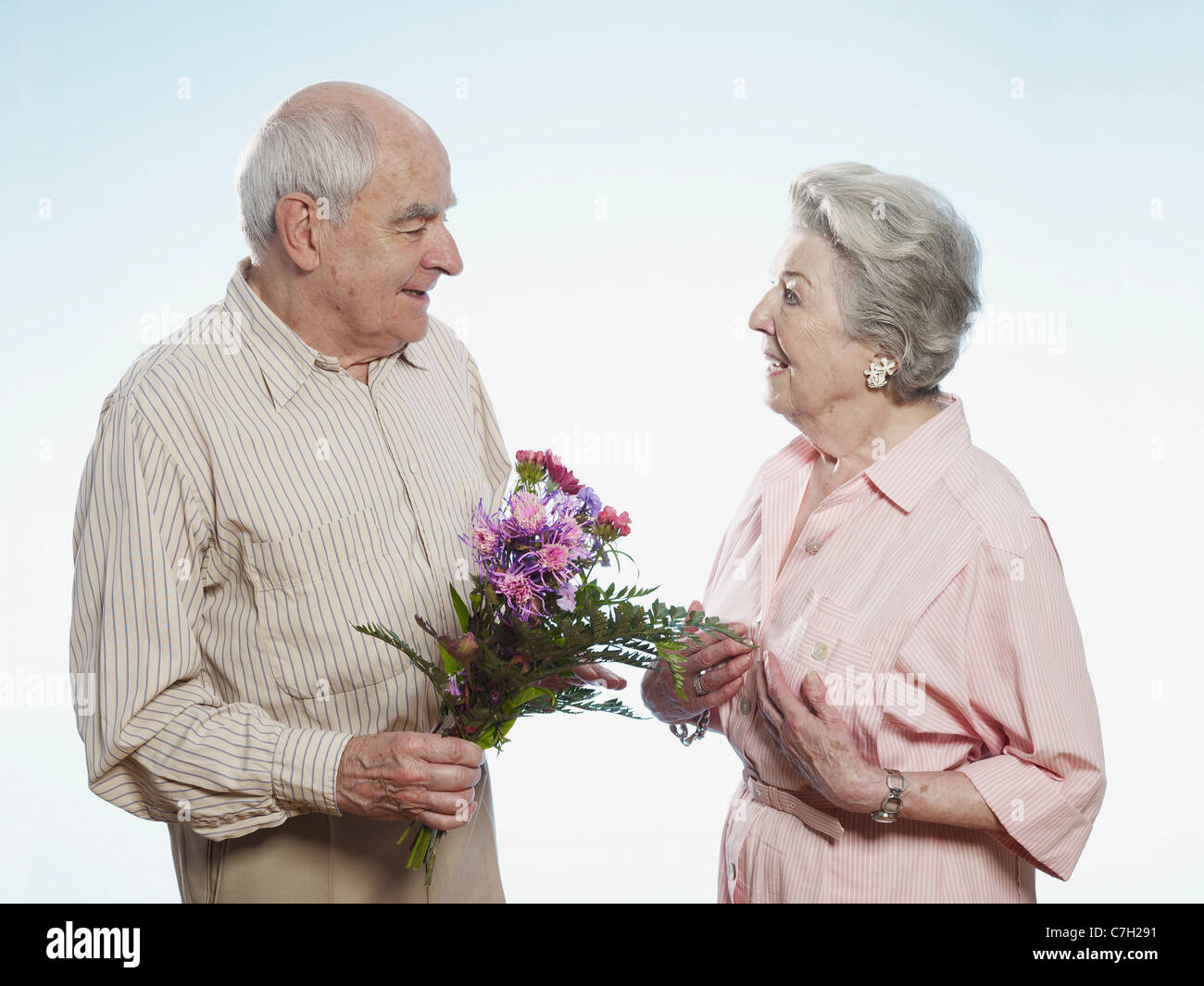 Senior woman gibt senior Frau Blumen Stockfoto
