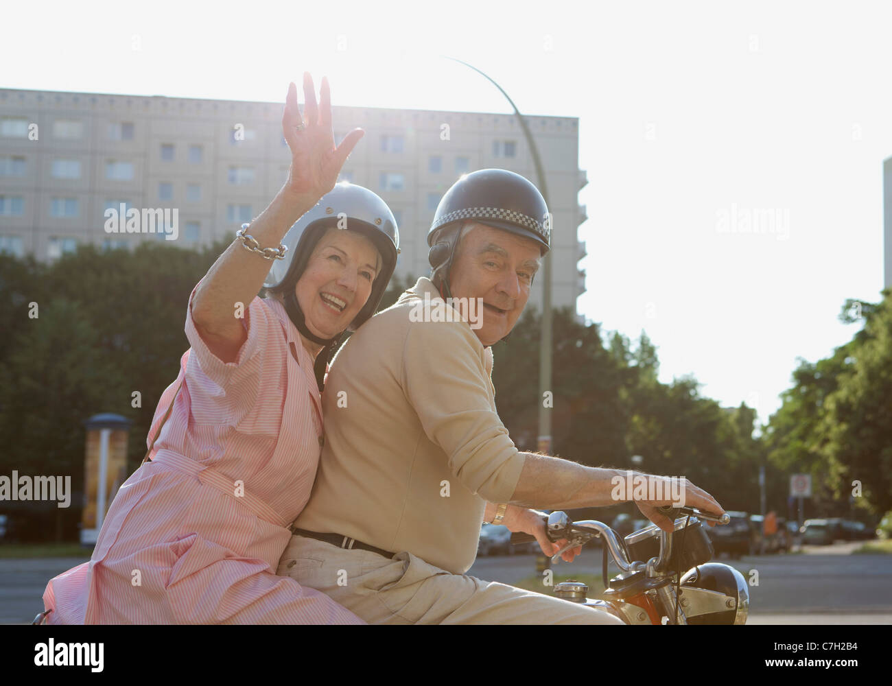 Älteres Paar glücklich auf dem Motorrad als Frau Wellen Stockfoto