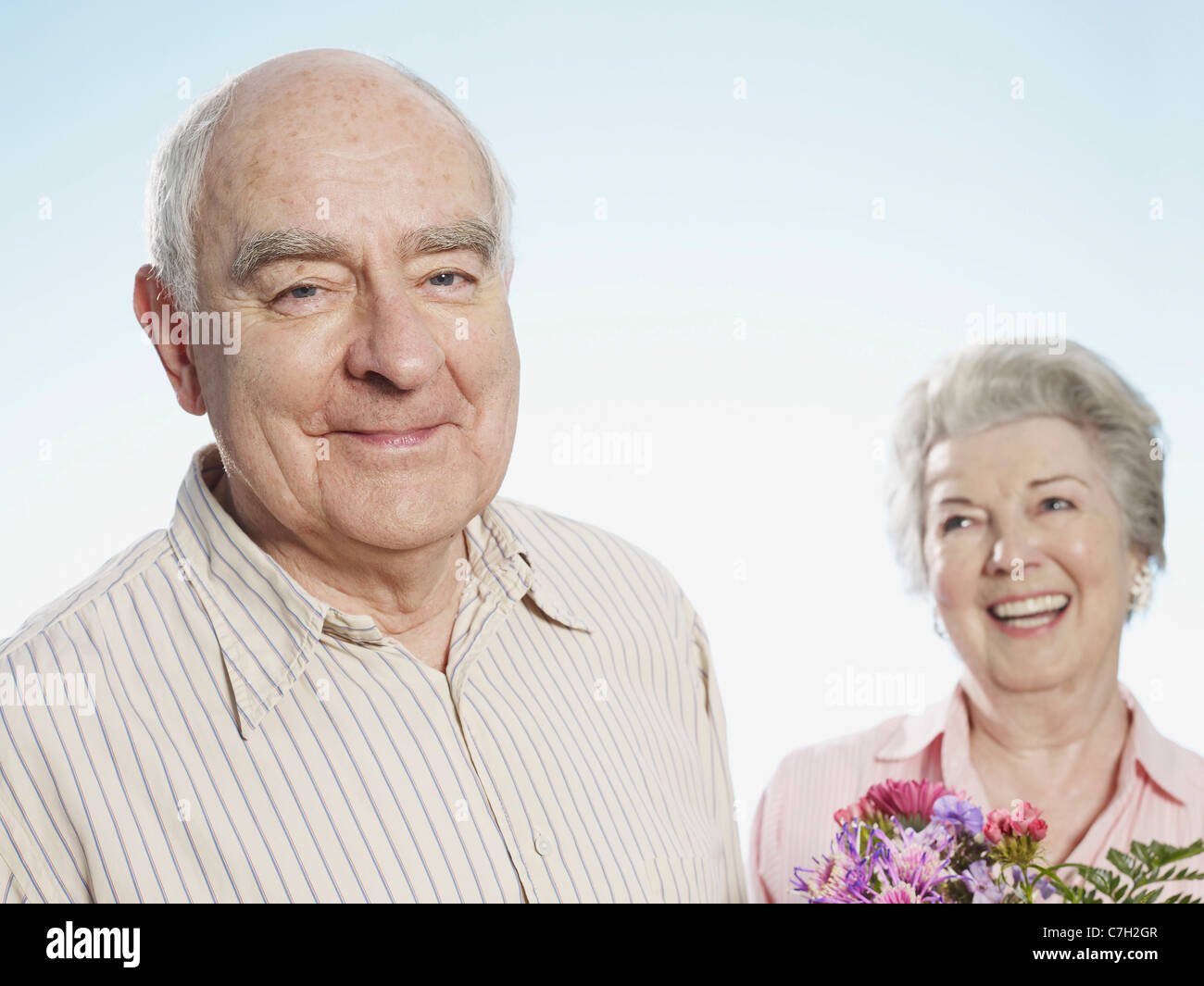 Ältere Mann sieht erfreut darüber, dass sie die Blumen liebt Stockfoto