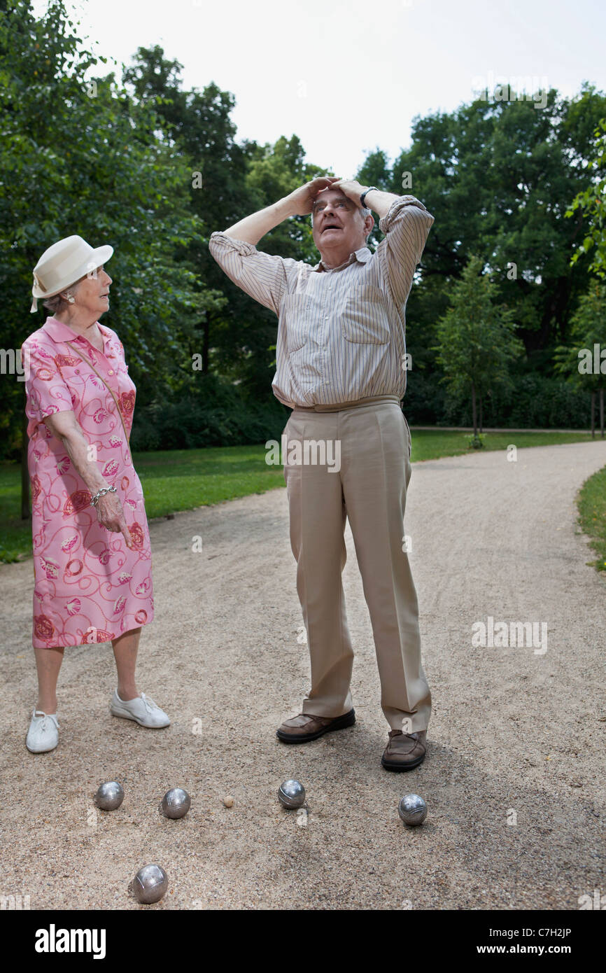 Senior paar beim Sport bestreiten, wie sie Boule im Park spielen Stockfoto