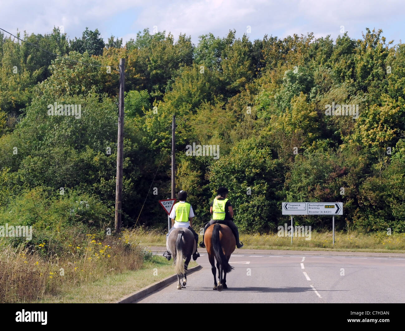 Zwei junge Reitern Reiten auf einer Hauptstraße an einer Straßenkreuzung Stockfoto