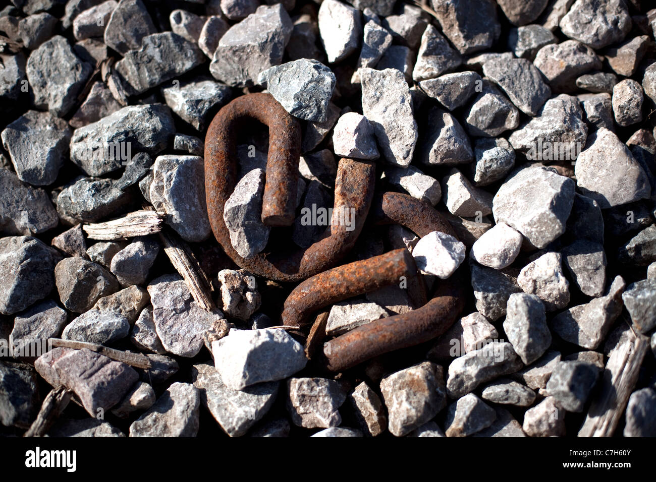 Rostige Kettenglieder eingebettet in Steinen auf dem Gelände einer stillgelegten Fabrik Stockfoto