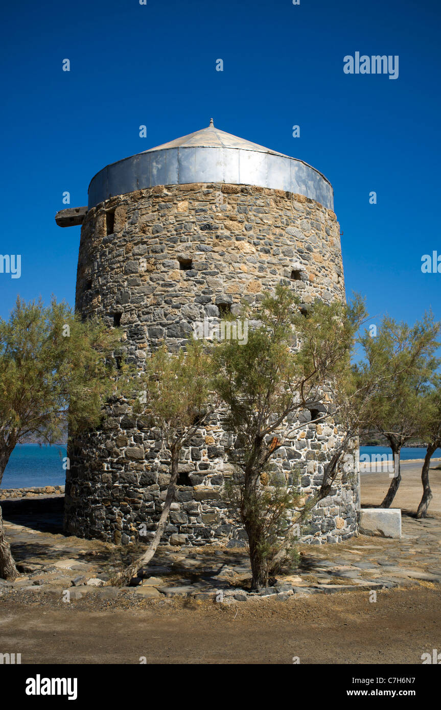 Eine stillgelegte Windmühle, umgeben von Olivenbäumen auf der Halbinsel in der Nähe der Ortschaft Elounda auf Kreta Spinalonga Stockfoto