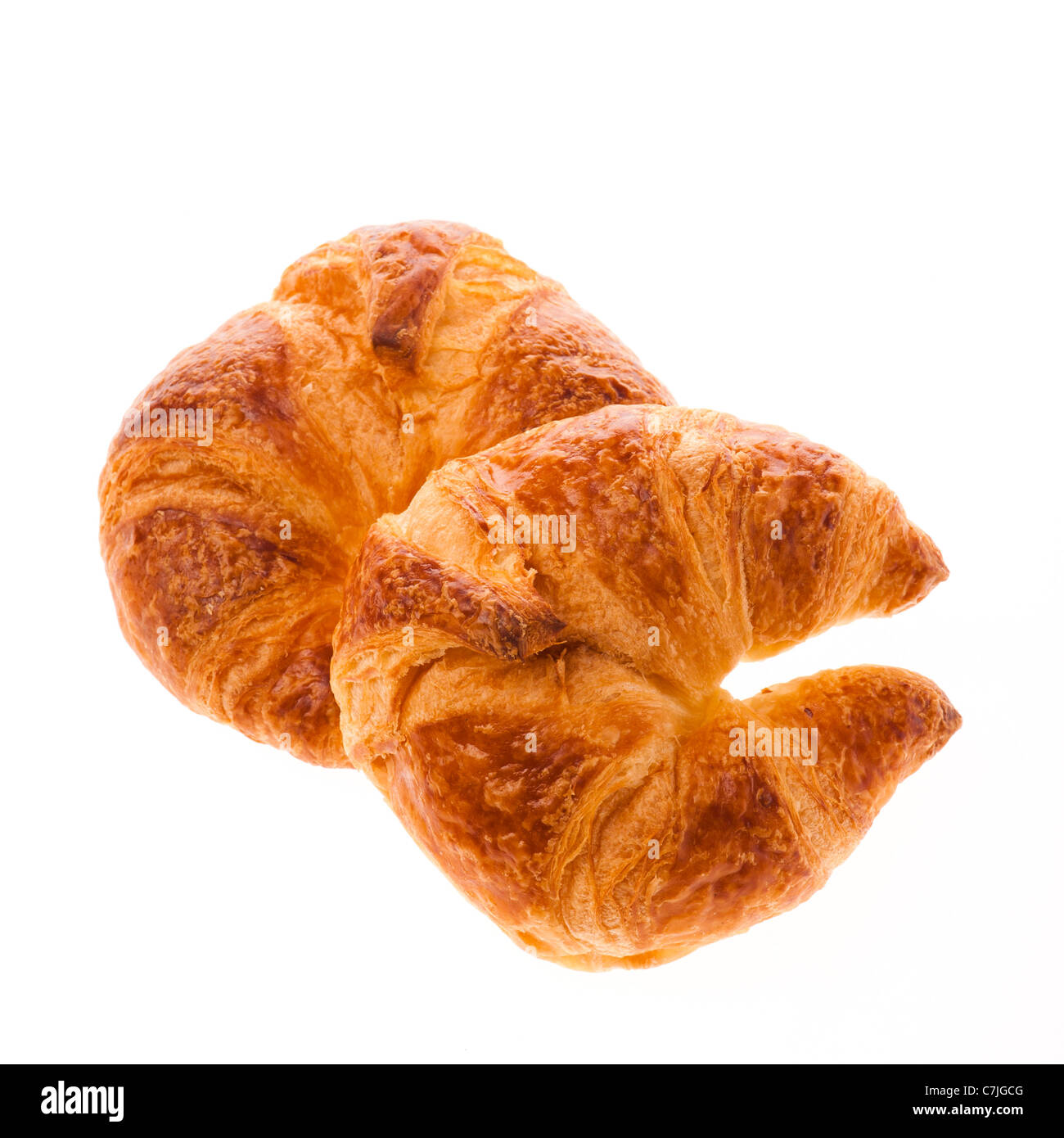Ein paar von frisch gebackenen Croissants auf einem weißen Hintergrundbeleuchtung-Hintergrund Stockfoto