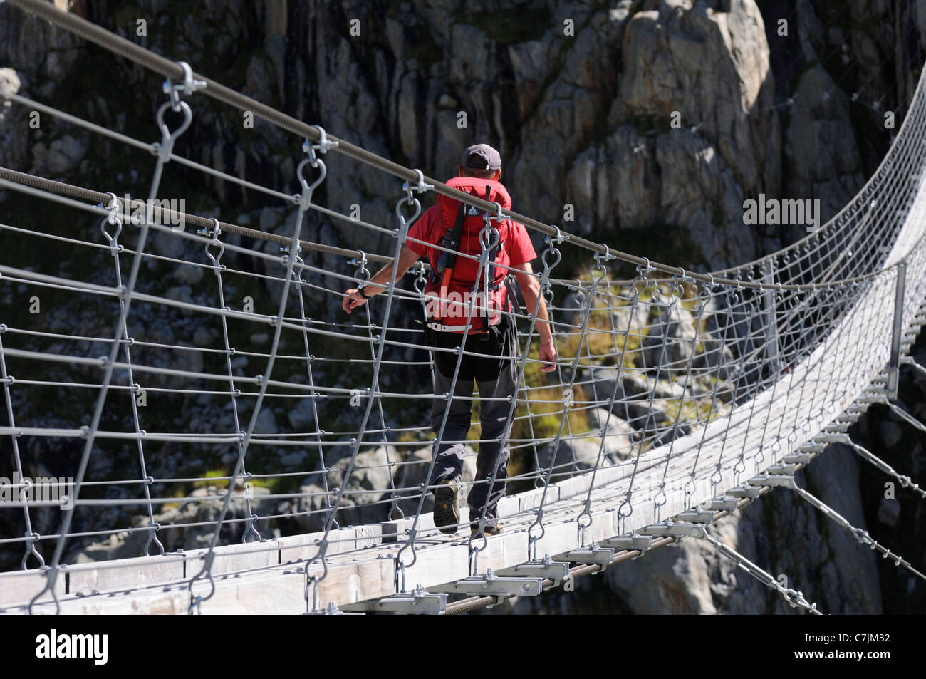 Schweiz, Kanton Bern, Trifttal. Einzelne Wanderer überqueren die Trift Drehbrücke mit einer Reichweite von 170 Metern. Stockfoto