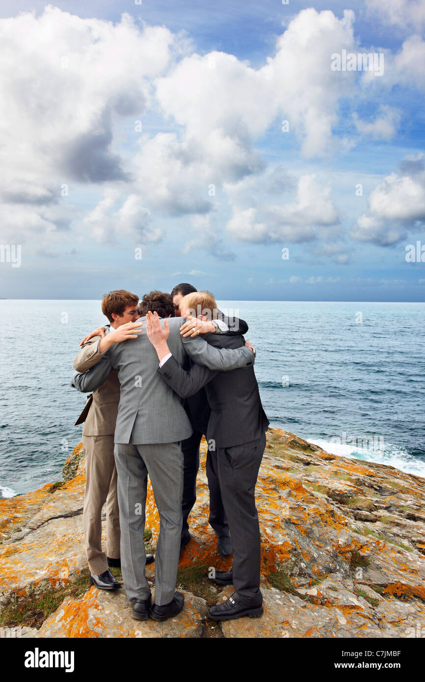 Geschäftsleute im Huddle auf Klippe sprechen Stockfoto