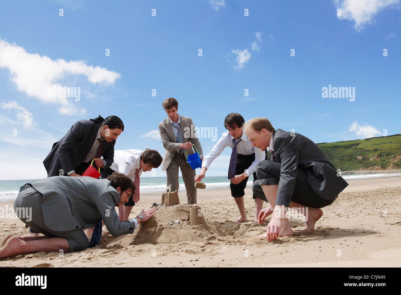 Geschäftsleute, die Sandburg bauen Stockfoto