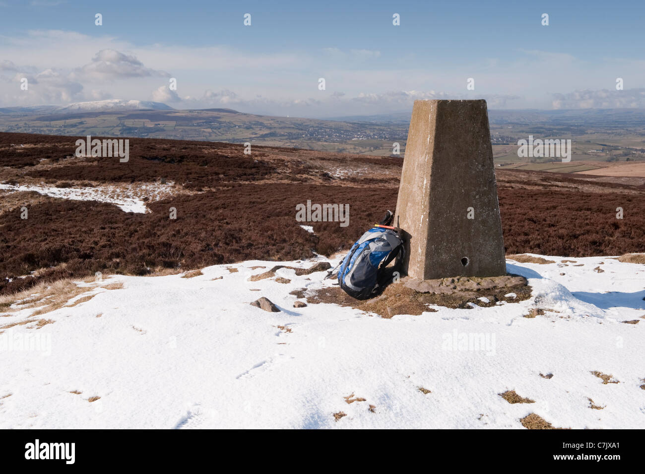 Berggipfel des Pinhow-Leuchtfeuers (Trig Point, Wanderrucksack, sonnenbeschienenen Hochmoor, landschaftlich reizvolle Aussicht, Winterschnee) - North Yorkshire, England, Großbritannien. Stockfoto