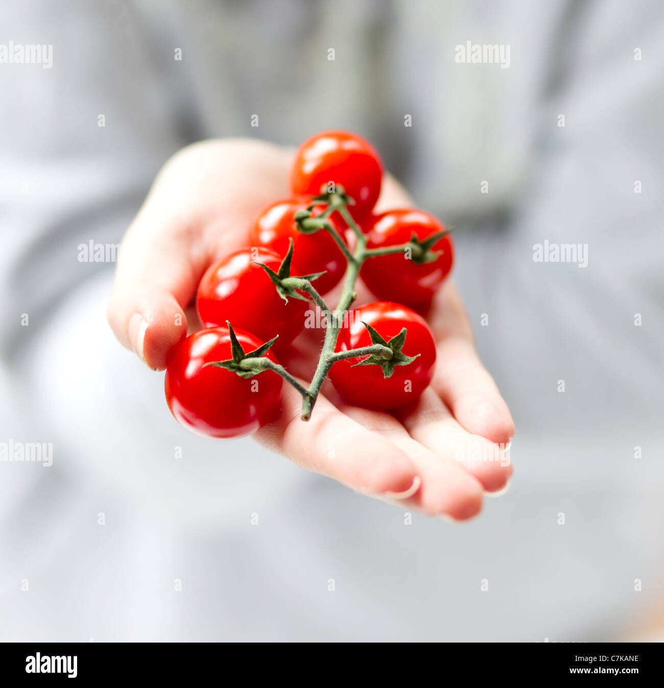 Frau-Holding-Cherry-Tomaten Stockfoto