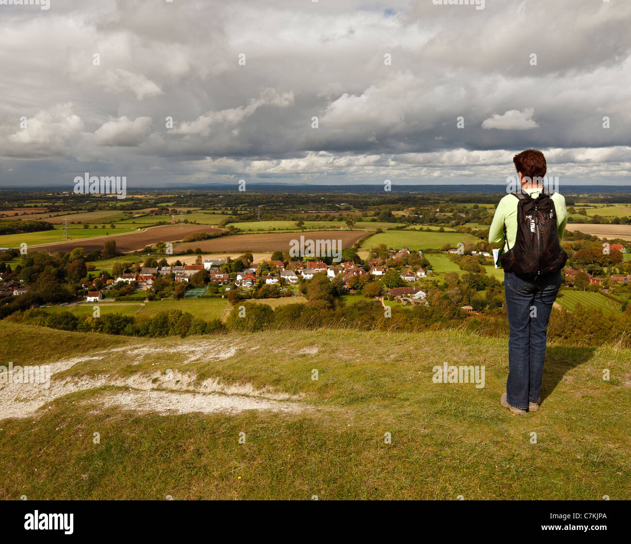 Frau zu Fuß entlang der Devils Dyke, Blick auf das Dorf Fulking und der Weald. Stockfoto