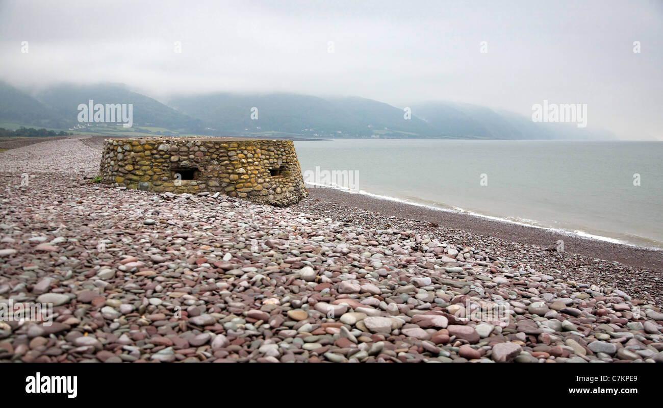 Dem zweiten Weltkrieg Pillenbox am Strand von Porlock Bucht in Somerset mit den Hügeln von Exmoor jenseits Stockfoto