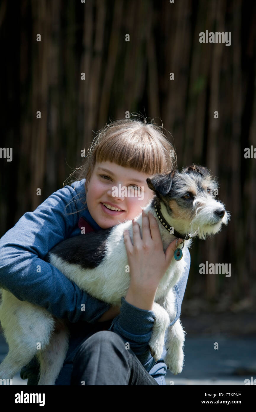 12-jähriges Mädchen mit ihrem Jack Russell-Hund im Garten spielen. Stockfoto