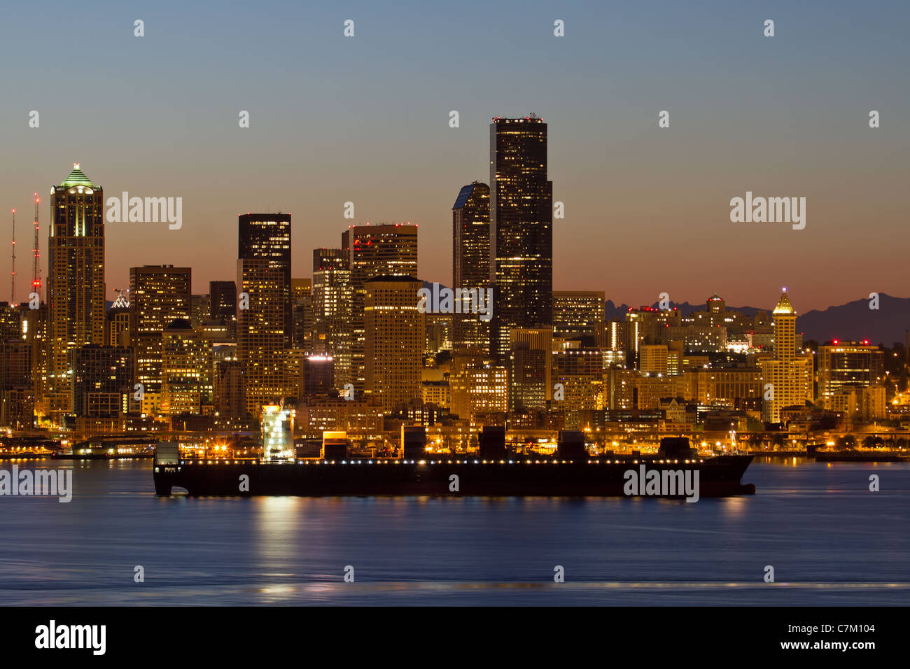 Containerschiff am Puget Sound entlang der Skyline von Seattle Washington im Morgengrauen Stockfoto