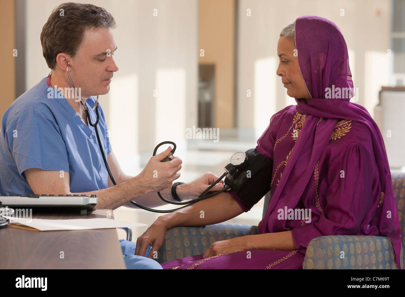 Pfleger des Patienten Blutdruck messen Stockfoto