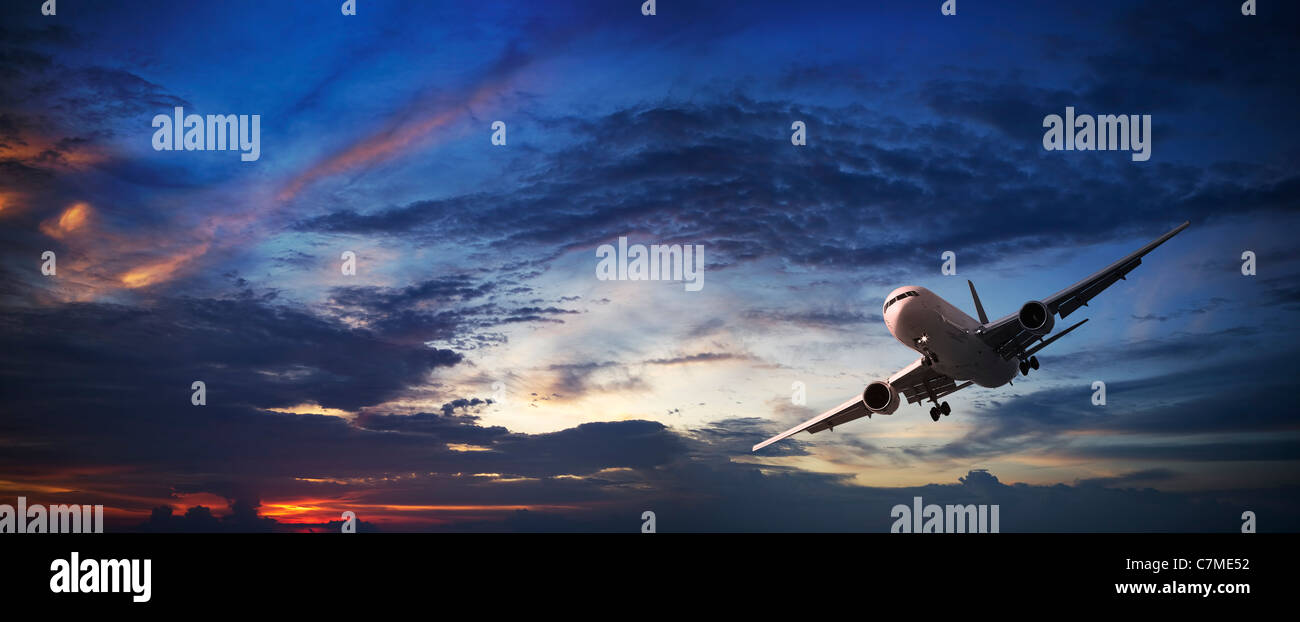 Jet-Flugzeugen Kreuzfahrt bei Sonnenuntergang. Panorama-Komposition. Stockfoto