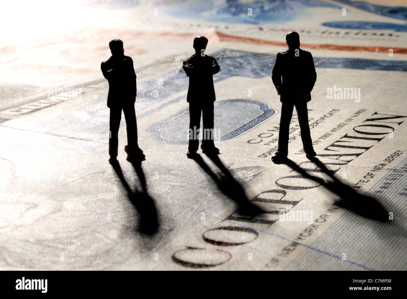 Geschäftsleute in Silhouette stehend auf Aktienurkunden - "Corporation" Stockfoto