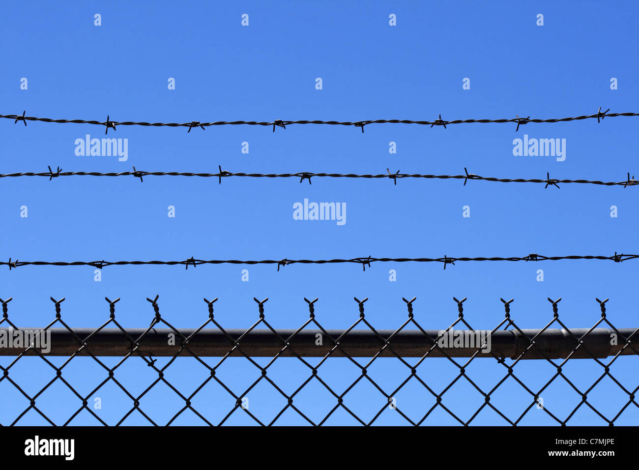 Kette Link und Barb Wire Zaun oben mit blauem Himmel Hintergrund und Kopie Stockfoto
