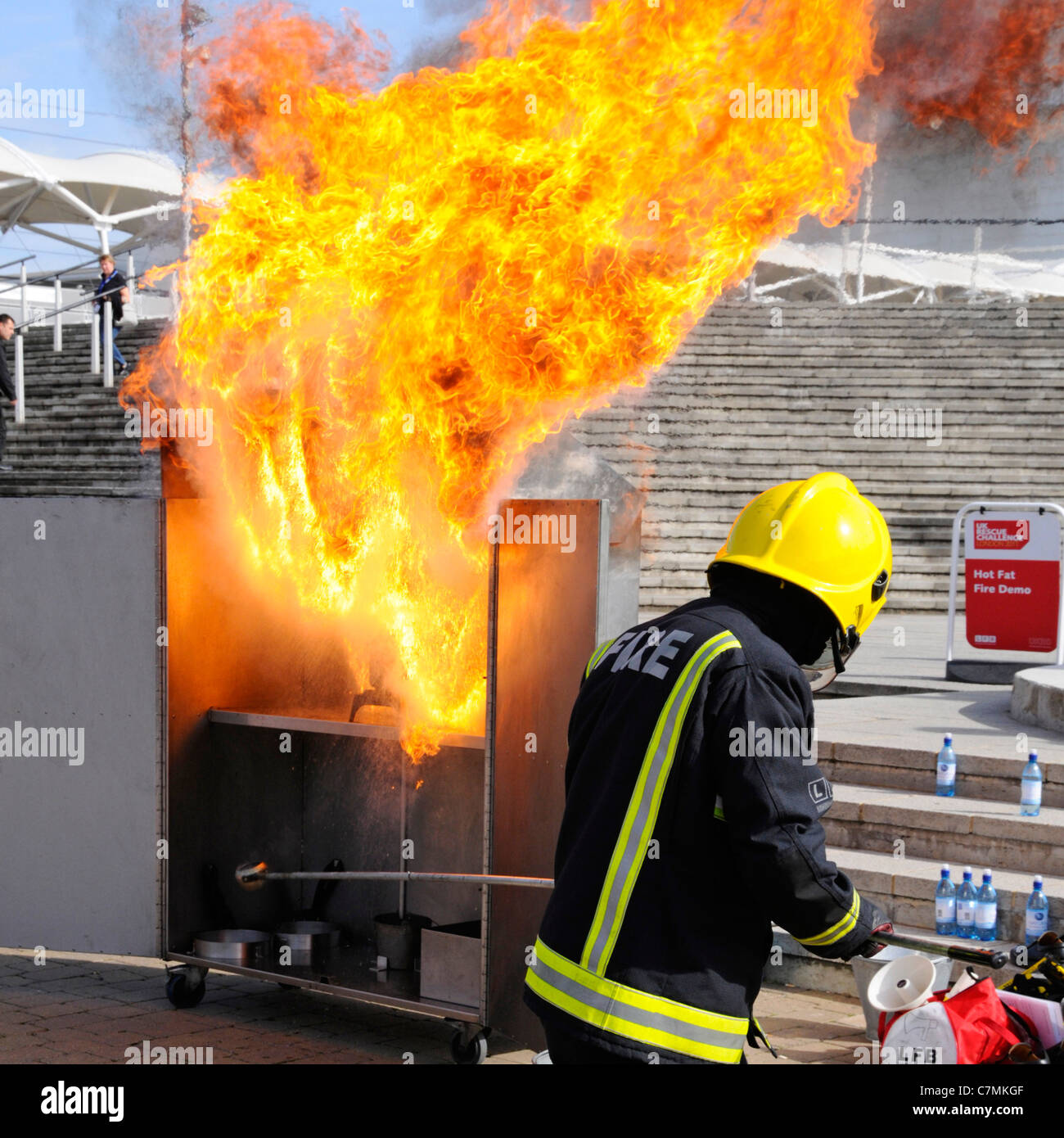 Heißes Fett Feuer Gefahr Demonstration durch die Londoner Feuerwehr bei UK Rescue Challenge Event Simulation Chip Pfanne Feuer mit Wasser Stockfoto