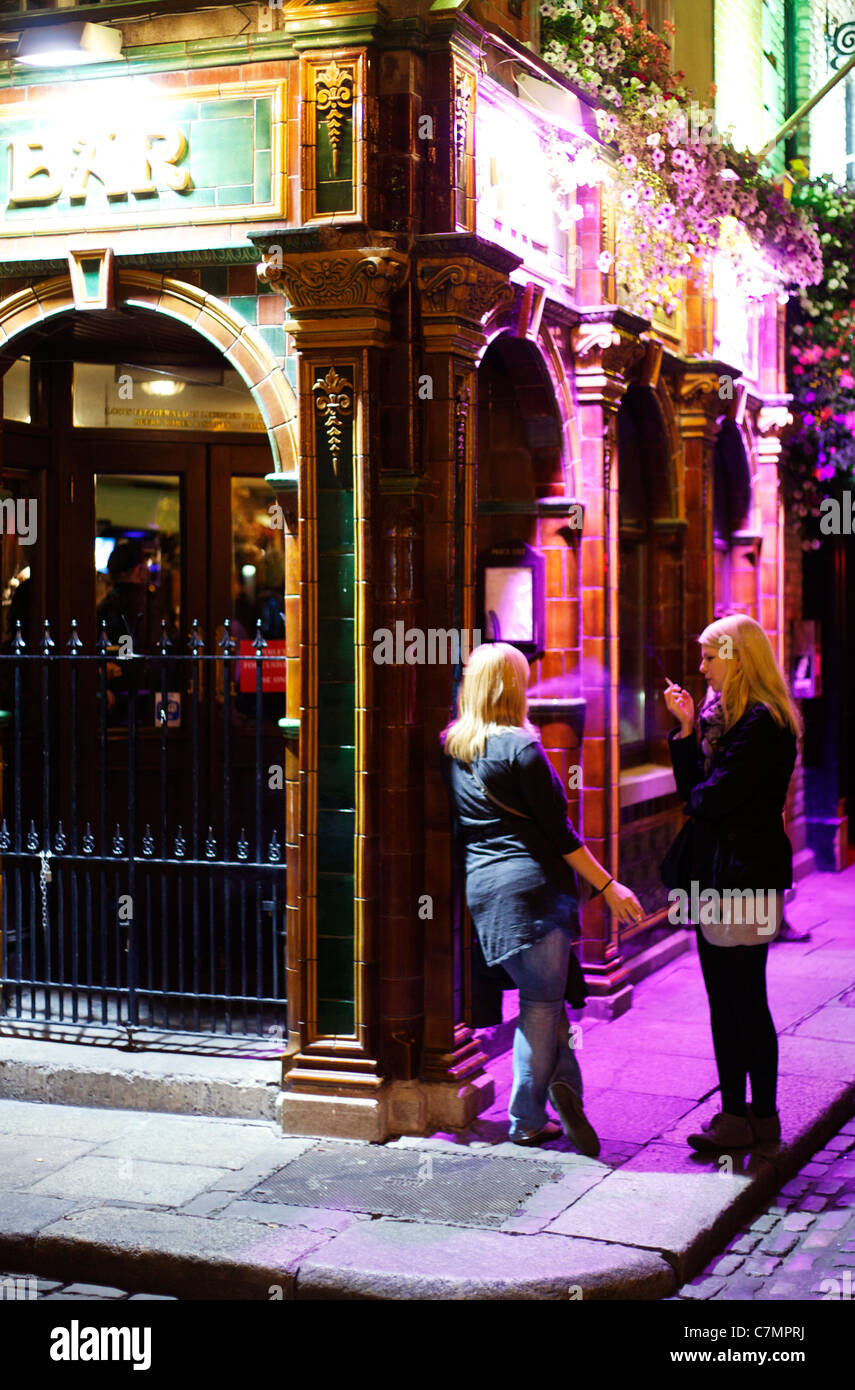 2 Mädchen außerhalb Dublin Pub Rauchen in der Nacht Stockfoto