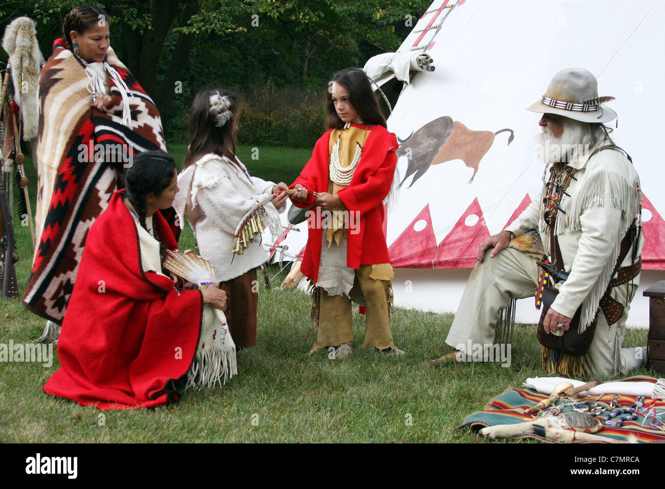 Native American Indianerjunge zeigt einer Mädchen, ein Musikinstrument Stockfoto