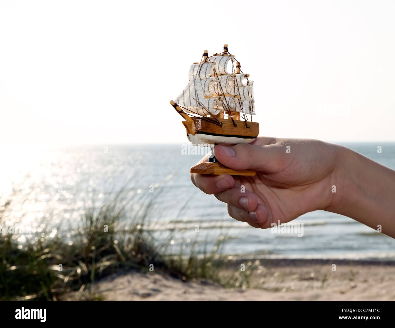 Mann hält Miniatur Schiff, Meer Hintergrund Stockfoto