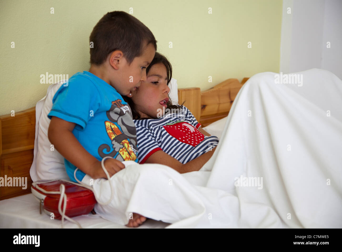 Kinder spielen von Computer-Spiel im Bett Stockfoto