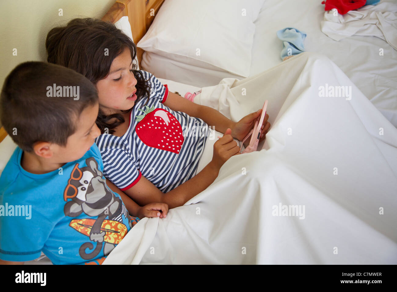 Kinder spielen von Computer-Spiel im Bett Stockfoto