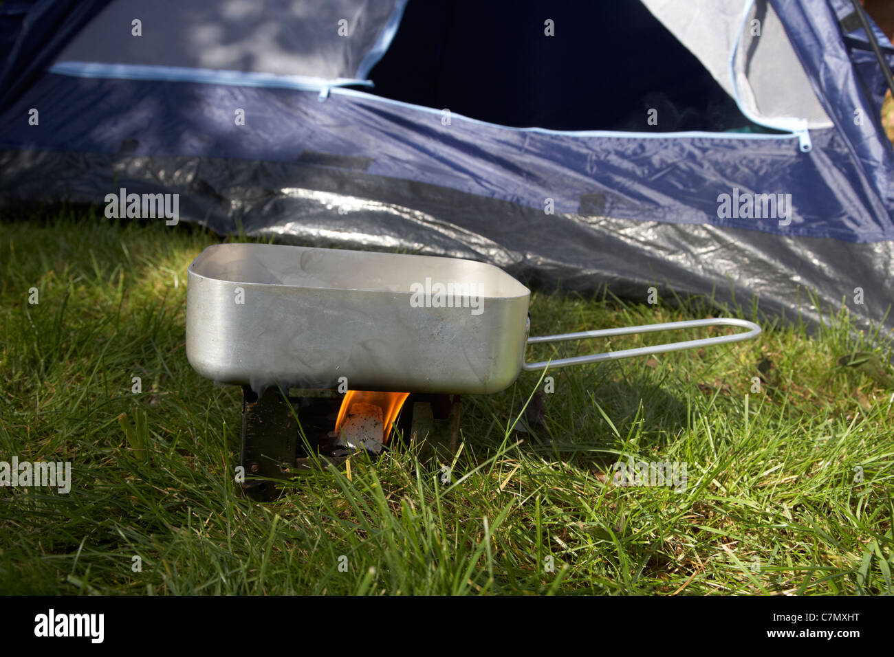 kleine Festbrennstoff Herd zum Heizen ein Chaos Zinn Wasser vor die offene Tür eines Zeltes genutzt Stockfoto