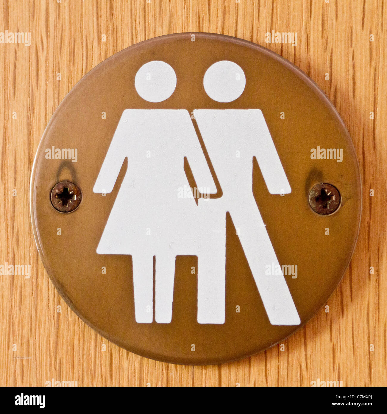 Zeichen, die Werbung einer unisex Toilette ein Standesamt in Essex; Das Weibchen scheint zu eng das Männchen streichelt sein Stockfoto