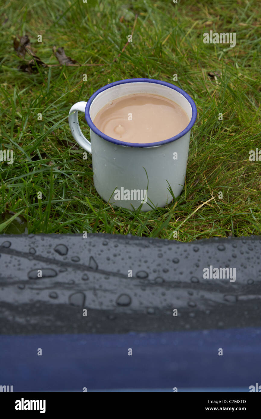 Tasse Tee mit Regen fällt es direkt vor einem Zelt Stockfoto