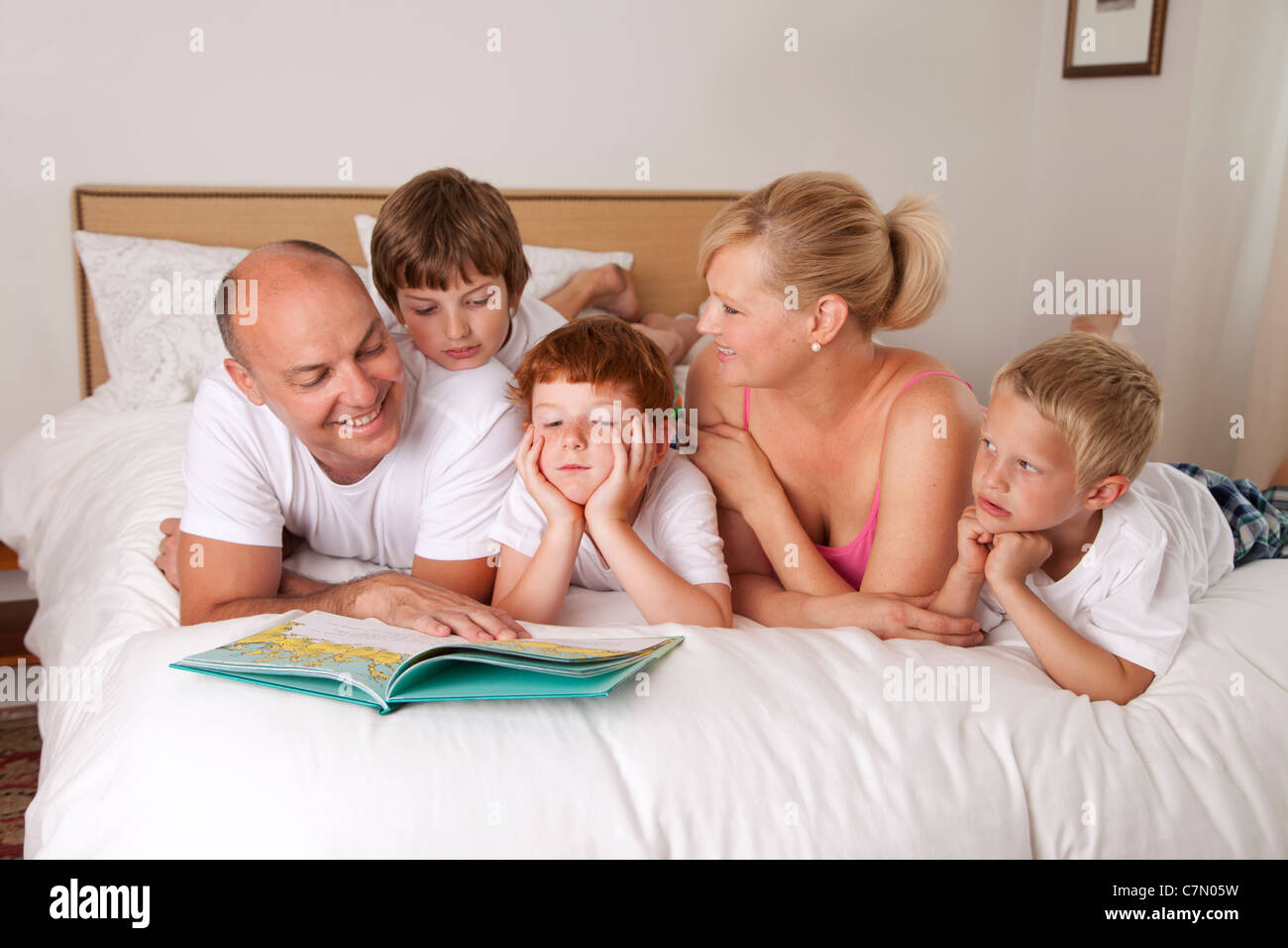 fünfköpfige Familie zusammen im Bett lesen Stockfoto