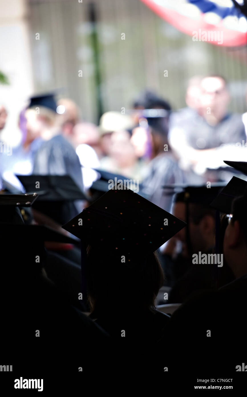 Silhouetten der Hochschule oder High School Absolventen tragen die traditionelle Mütze und Mantel. Geringe Schärfentiefe. Stockfoto
