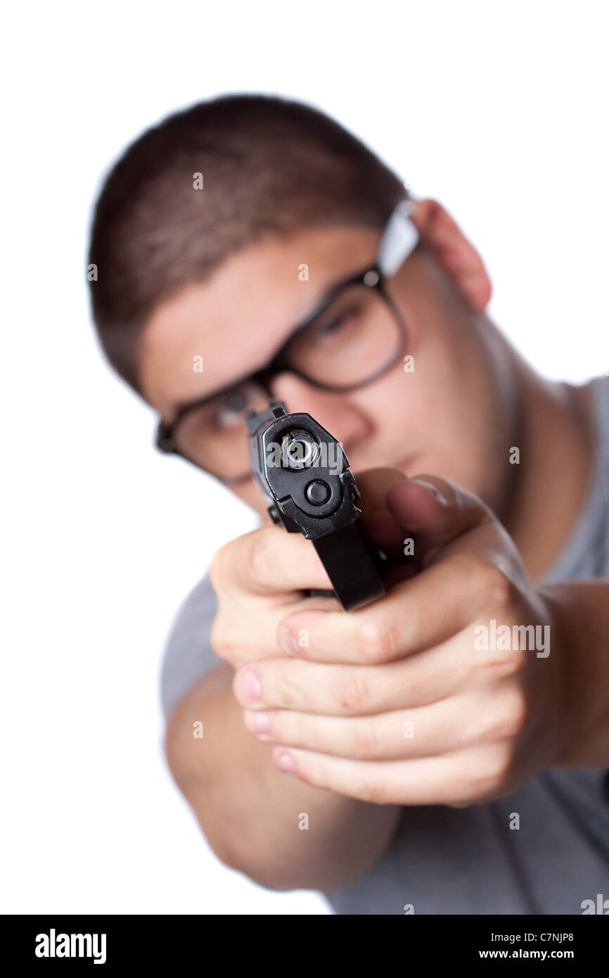 Eine böse aussehende Teenager mit Brille zeigt eine schwarze Pistole auf den Betrachter. Geringe Schärfentiefe. Stockfoto