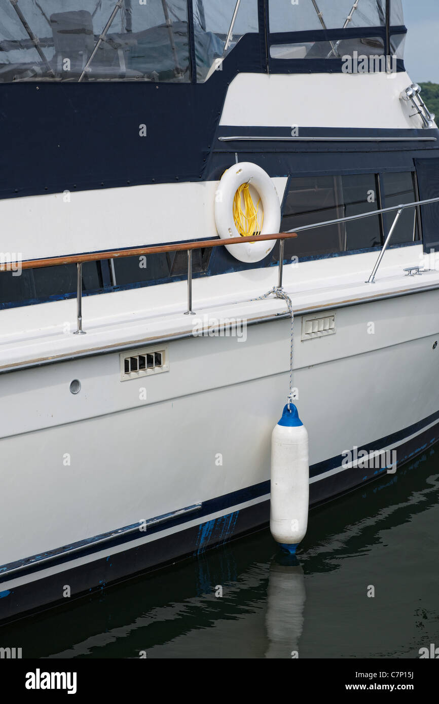 Rumpf des vertäut Kajütboot mit weißen dock Stoßstange hängenden auf Seite des Rumpfes für Schutz Stockfoto