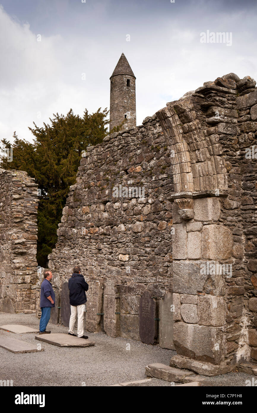 Irland, Co. Wicklow, Glendalough, historische klösterliche Stätte, Rundturm Besucher in der zerstörten Kathedrale nahe an Stockfoto