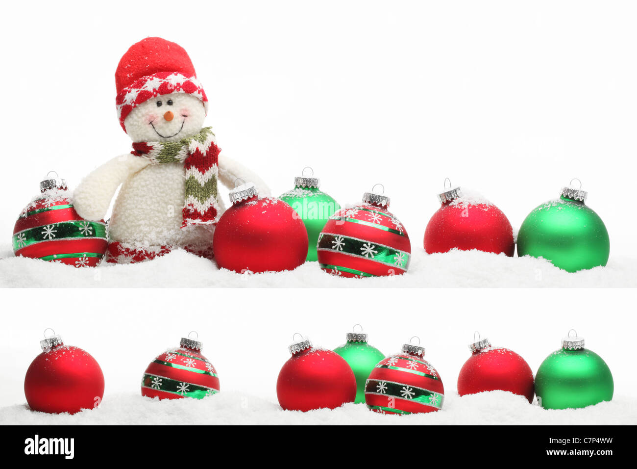 Weihnachts-Dekoration mit Schneemann und Kugeln auf Schnee. Stockfoto