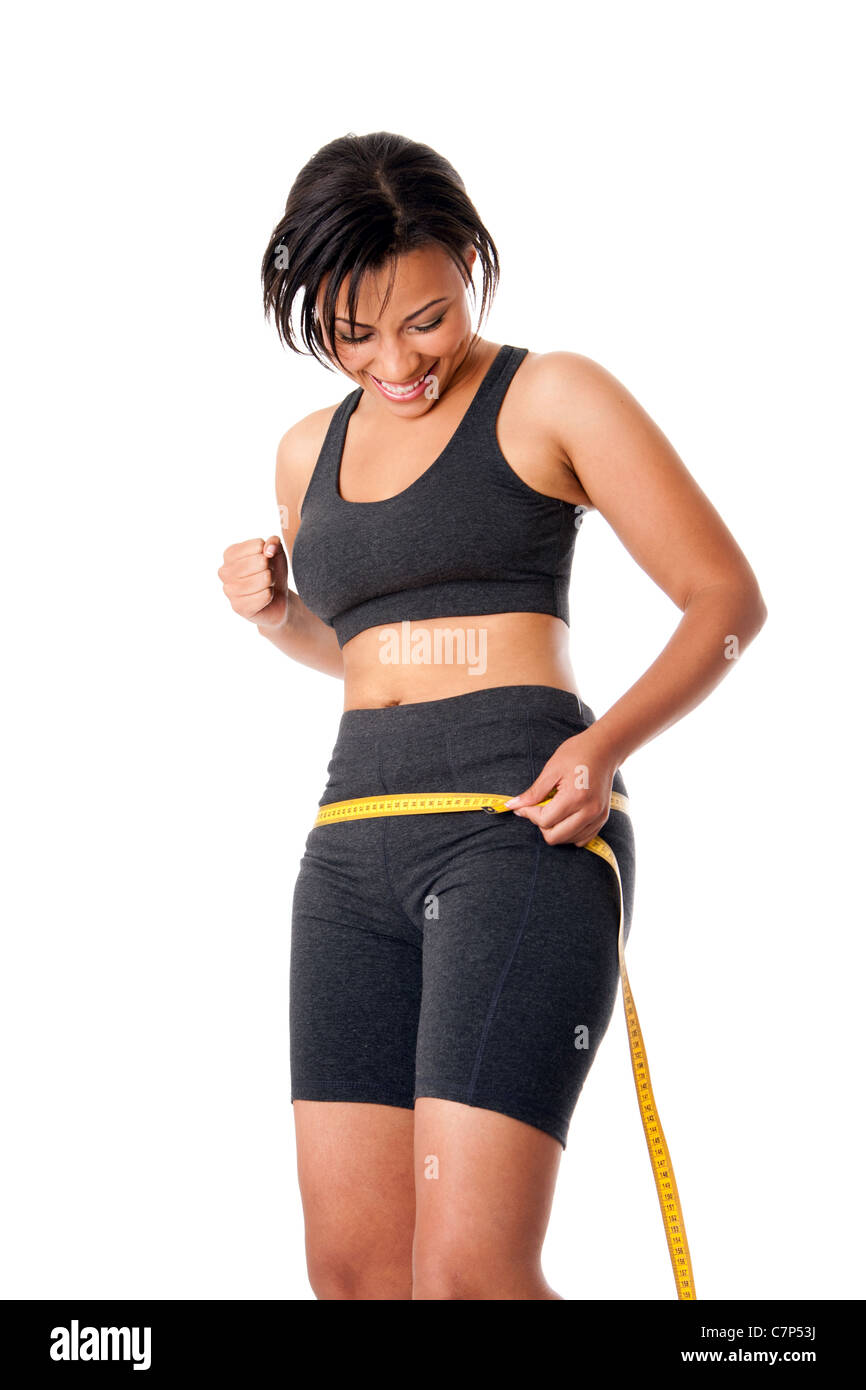 Frau-Gewichts-bewusste Messung ihrer Grösse Form um Taille Hüfte, feiert ihr erfolgreiches abnehm. Stockfoto