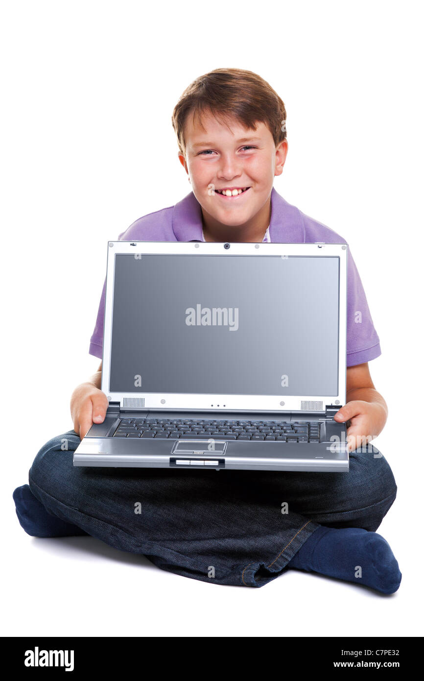 Ein 11 Jahre alter Junge mit einem Laptop-Computer, isoliert auf weiss mit Beschneidungspfad für den leeren Bildschirm. Stockfoto