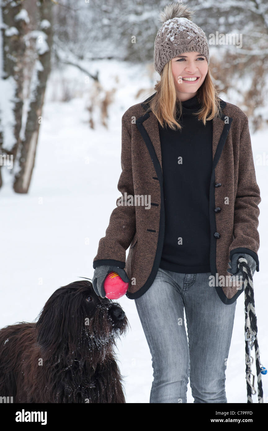 Frau zu Fuß Hund im Schnee Stockfoto