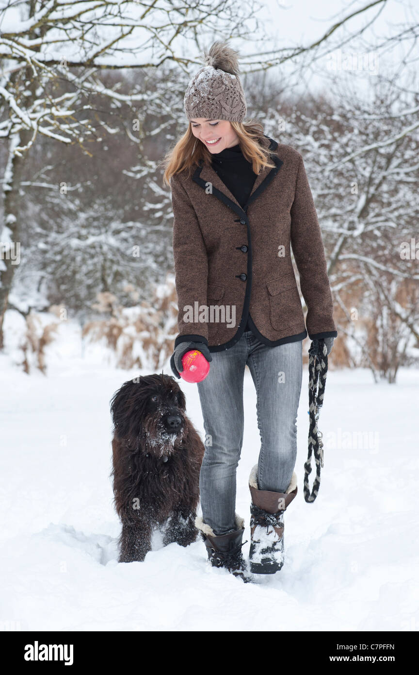 Frau zu Fuß Hund im Schnee Stockfoto